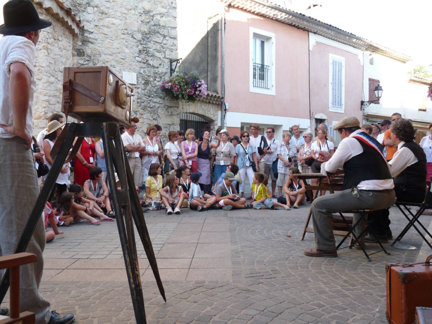 comediens en jeu sur une place de village